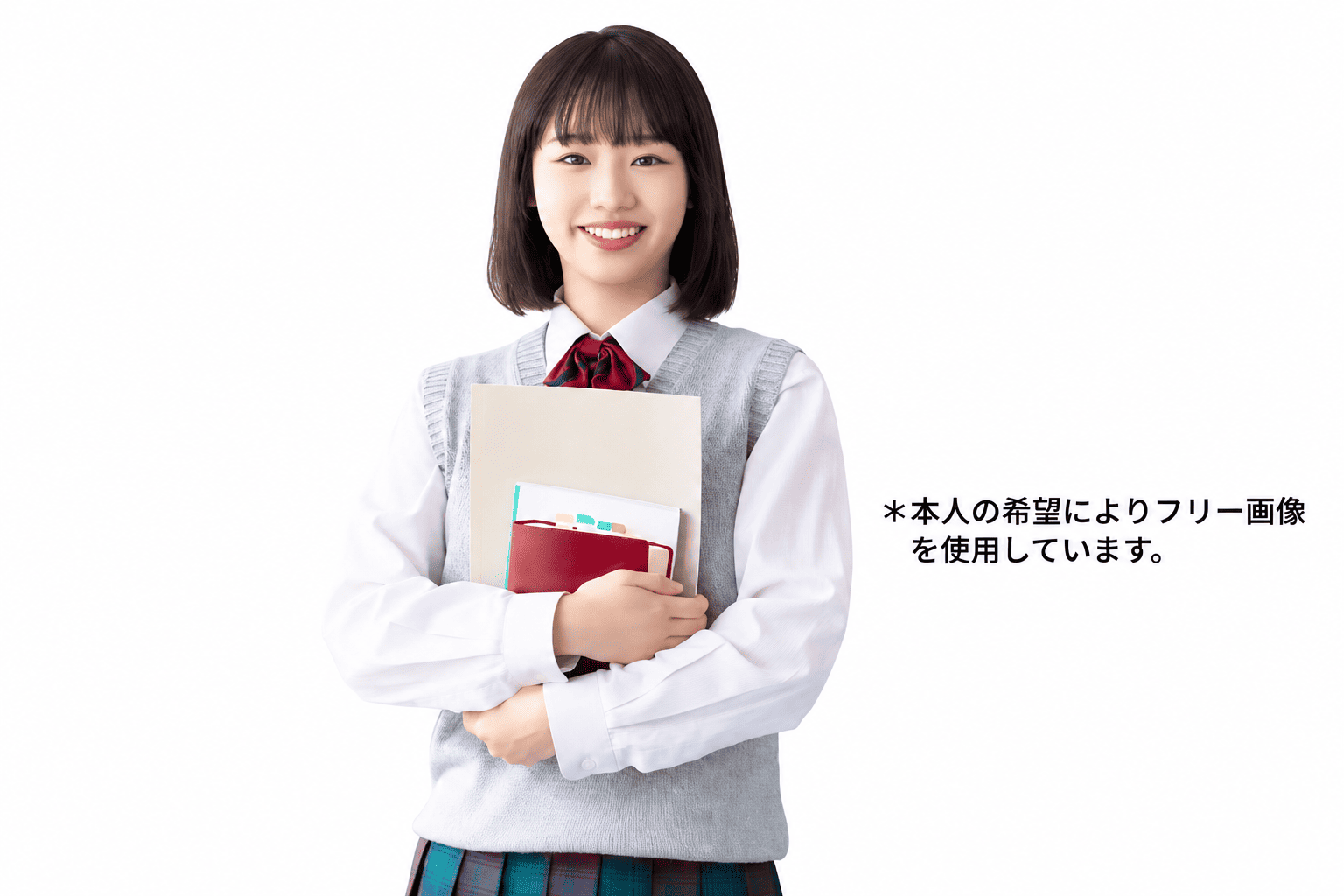 Smiling student in a light gray sweater vest and white shirt, holding notebooks and folders against a white background.