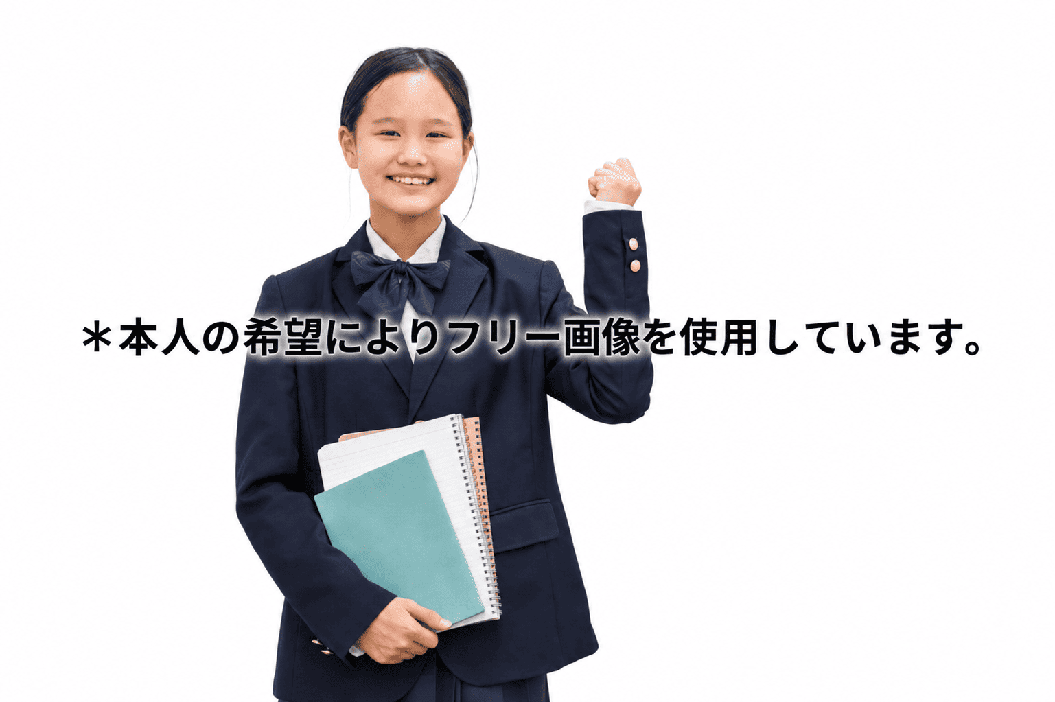 Smiling schoolgirl in a dark navy uniform holds notebooks and raises a clenched fist in a confident pose. Text overlay reads: 本人の希望によりフリー画像を使用しています。