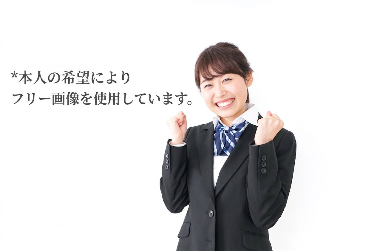 Smiling businesswoman in a black blazer with a blue scarf, fists raised in celebration; Japanese note states the image is a free stock photo.